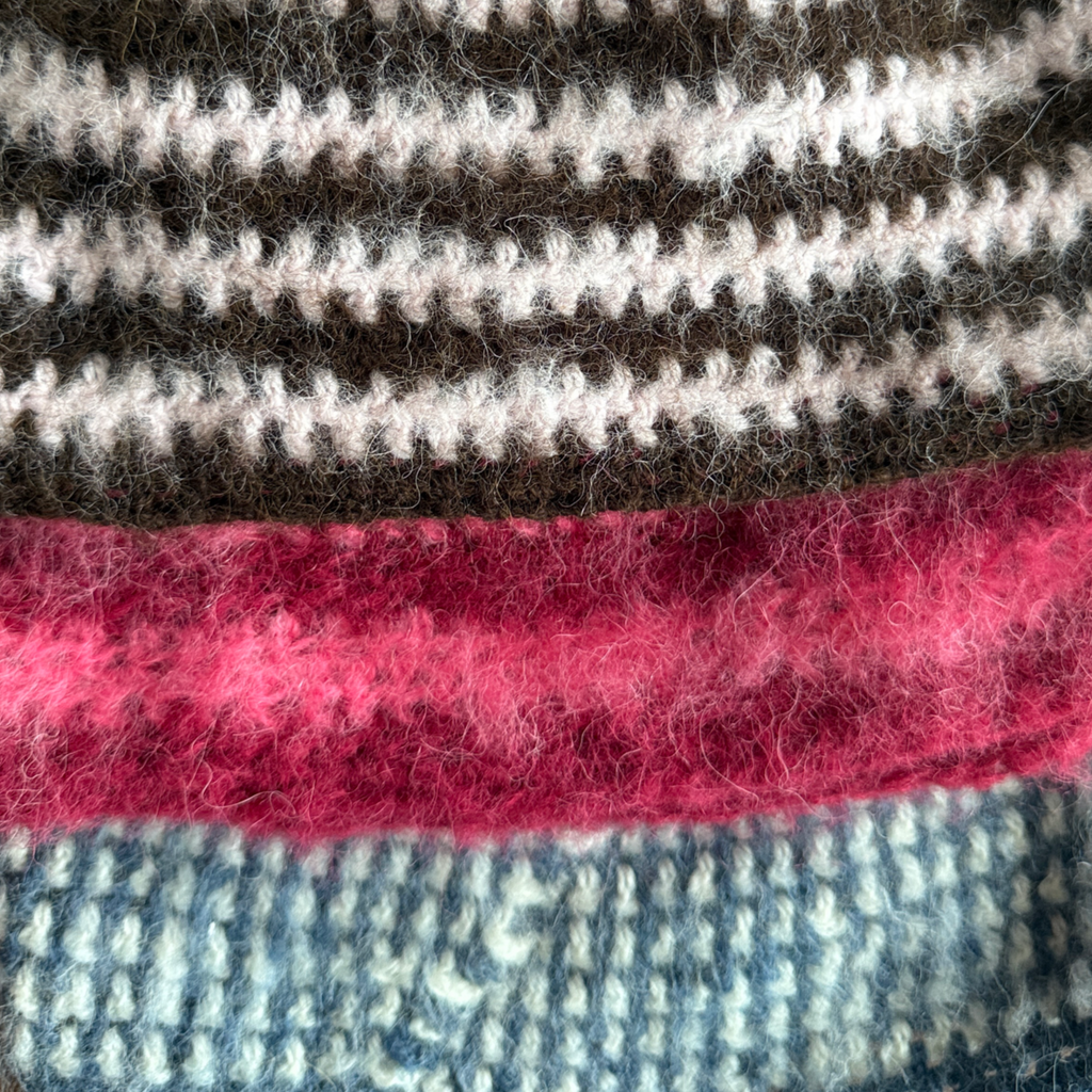 Close-up of textured fabric with pink, brown, blue and white stripes.